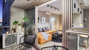 Un intérieur moderne avec un canapé, un fauteuil, une petite table et une plante en pot.