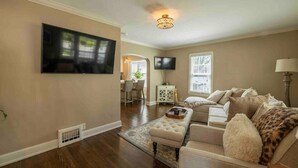 A living room with a flat-screen TV, a sofa, a coffee table, and a lamp.