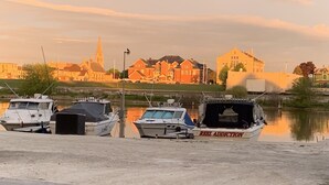 A marina with boats docked, a church, and residential buildings in the background. - Lovely Riverfront views of river. Walking distance to beach.  🚴👙🐠 (Two Rivers)