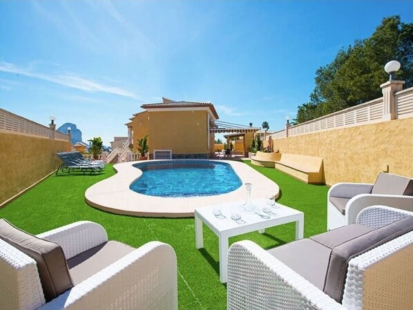 A backyard with a swimming pool, lounge chairs, and a small table. - Casa Rose Calpe 4-Bed villa with private pool (Calpe)