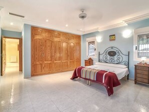 A bedroom with a bed, wooden wardrobe, and a nightstand. - Casa Rose Calpe 4-Bed villa with private pool (Calpe)