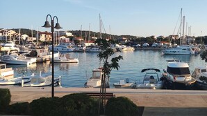 A marina with various boats docked, a clear sky, and buildings in the background. - Stunning 2-Bed House in Jezera with Sea views (Jezera)