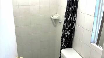 Un baño pequeño con inodoro, bidé y ducha.