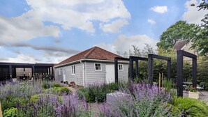 Ein Haus mit Garten, umgeben von verschiedenen Pflanzen und Blumen.