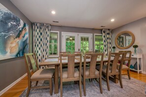 Un comedor con una mesa dispuesta para seis personas, rodeada de sillas.