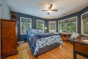 A bedroom with a bed, dresser, and a ceiling fan.