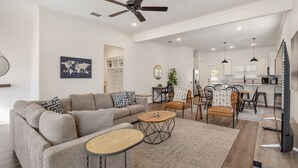 A spacious living room with a sofa, coffee table, and dining area.