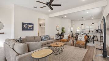 A spacious living room with a sofa, coffee table, and dining area.