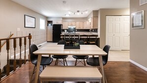 A modern kitchen with a central island, wooden cabinets, and a dining area with a table and chairs. - Skyline - Military/Family Friendly (Shiloh)