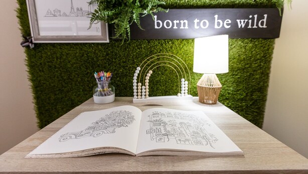 A desk with an open sketchbook, a lamp, and a wall-mounted sign that reads "born to be wild." - Skyline - Military/Family Friendly (Shiloh)