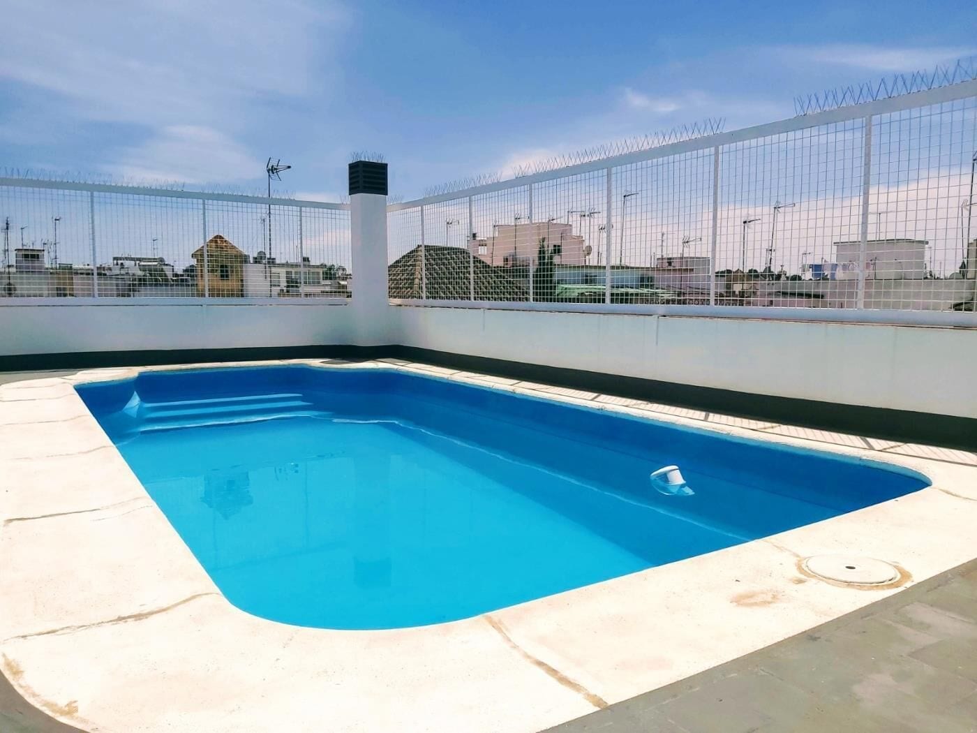 A rooftop swimming pool with a clear view of the surrounding buildings.