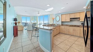 Una cocina moderna con una isla central, un comedor con vistas y un ventanal grande.