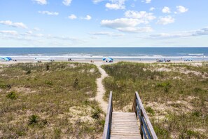Walk along the beachside boardwalk surrounded by lush dunes and enjoy the serene ocean views.