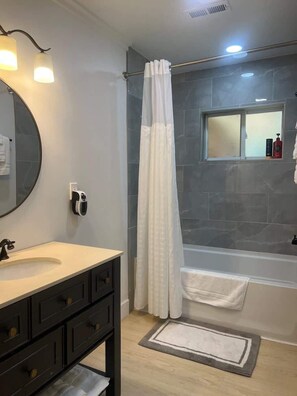 Bathtub, hair dryer, towels, shampoo