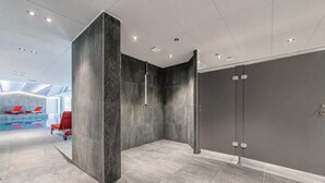 A modern indoor pool area with a clear view of the pool, red lounge chairs, and a large dark wall. - Mont blanc view with private sauna, Argentière (Chamonix), France (Argentière (Chamonix))
