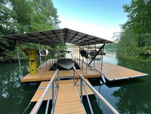 Relax on the dock's covered seating area, surrounded by calm waters and lush greenery.