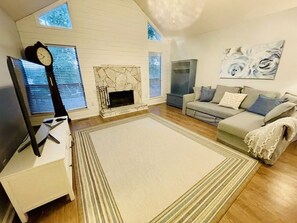 Cozy living room with a fireplace, sofa, and flat-screen TV.