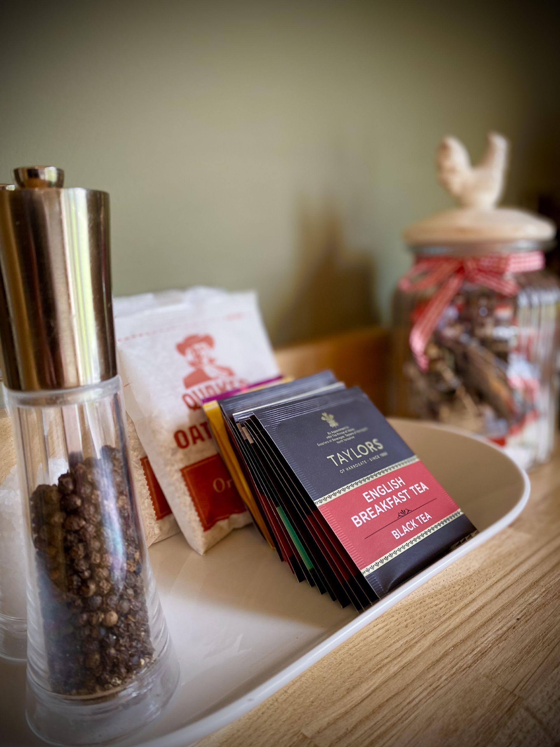 A tray with a jar of spices, a packet of tea, and a stack of tea bags.