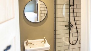 A bathroom with a wooden ceiling, a round mirror, a sink, and a glass-enclosed shower. - Meadow View  - (Bottom Cabin)  - sleeps 2 guests  in 1 bedroom (Foolow)
