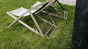 A grassy area with two wooden folding chairs and a gravel path. - Meadow View  - (Bottom Cabin)  - sleeps 2 guests  in 1 bedroom (Foolow)