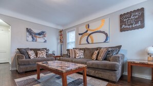 Ein Wohnzimmer mit zwei Sofas, einem Couchtisch und Wanddekoration.