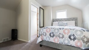 Ein Schlafzimmer mit Bett, Heizung, Fenster und Tür.