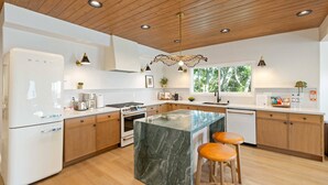 A modern kitchen with wooden cabinets, a marble island, and bar stools. - Voted Guest Favorite! Get Wow'd! Stellar Views Hollywood Hills (Los Angeles)