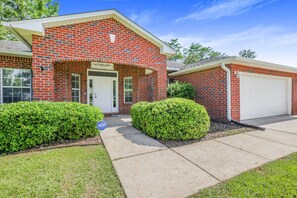 A two-story brick house with a garage, a front porch, and a well-maintained lawn. - Spacious 4 bedroom house by OWA & Tanger Outlets, 15 mins from Beaches (Foley)