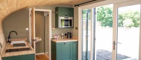 A compact kitchen with a microwave, sink, and cabinets.