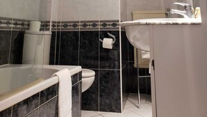 Une salle de bain moderne avec une douche à parois de verre, des toilettes et un lavabo avec un miroir.