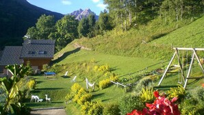 A rural setting with a house, a swing set, and a path leading to it. - Studio cabin Valloire 4 pers South - Pets allowed, Wifi (Valloire)