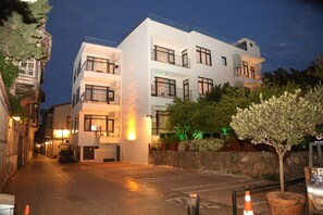 Un edificio moderno con varios balcones y una entrada bien iluminada.