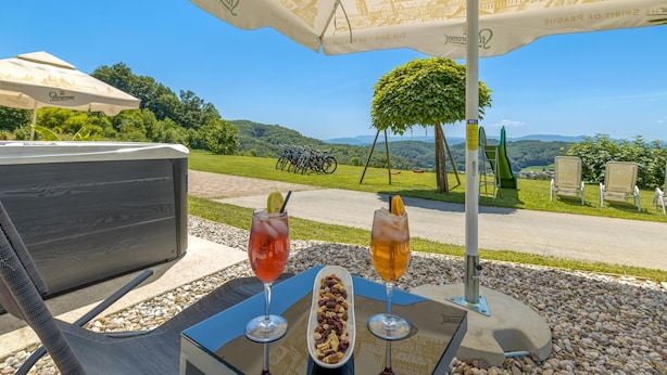 Un espace extérieur aménagé avec une table, deux boissons et une assiette de noix.