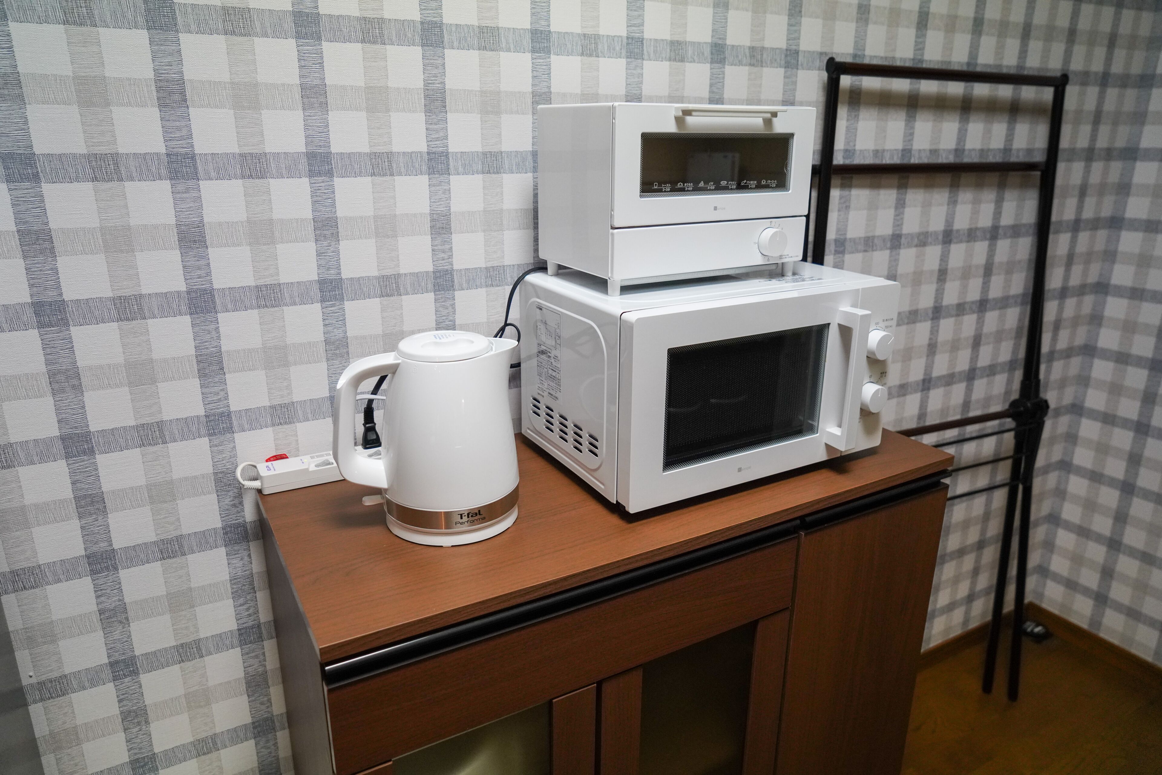 A kitchenette with a microwave, a coffee maker, and a small oven on a wooden countertop.
