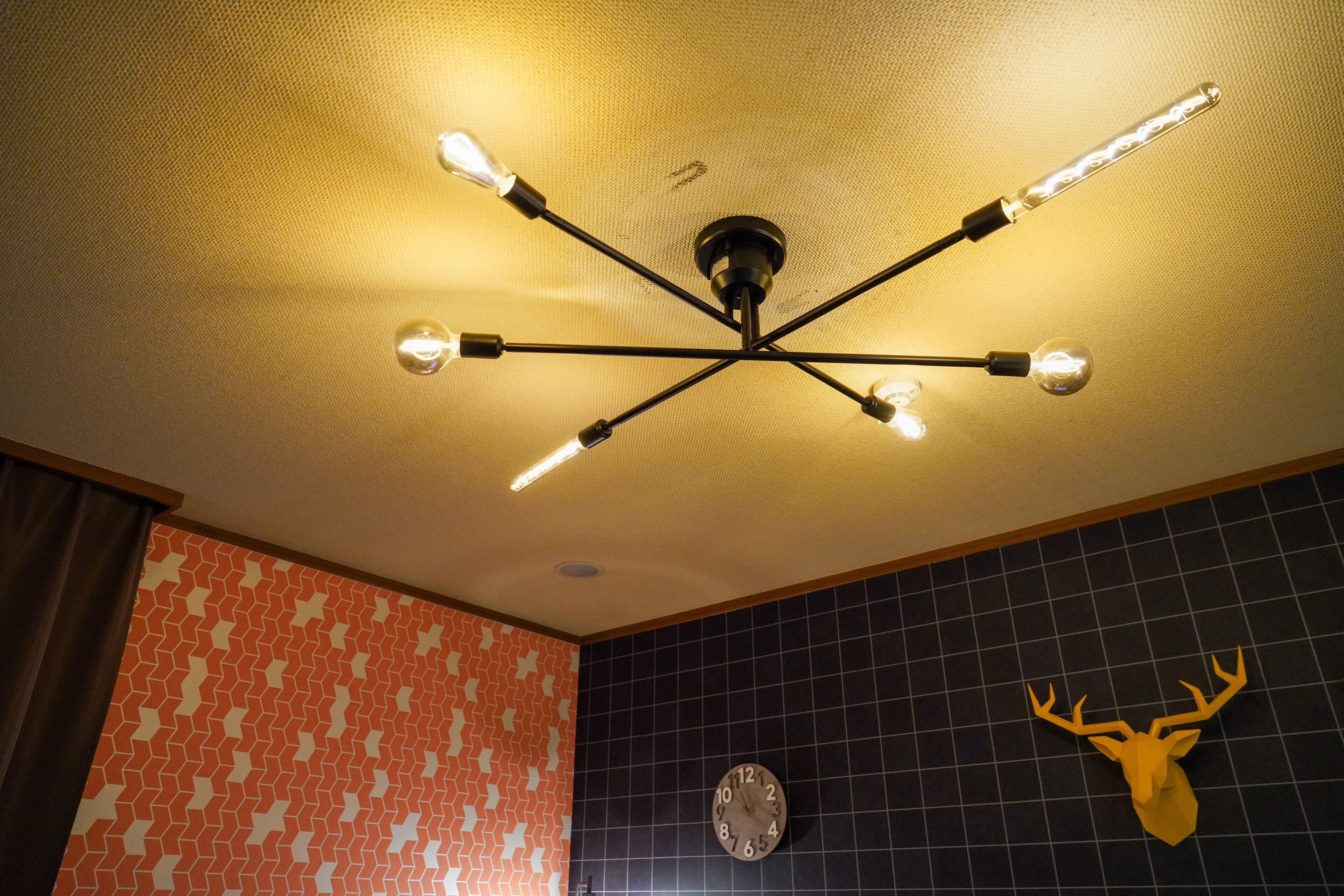 A ceiling with a modern light fixture and a wall clock.