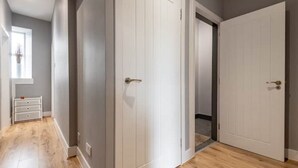 A hallway with two white doors, a small white dresser, and a window with a plant. - No 65 Leuchars (Nr St Andrews) Free Parking - Pet Friendly (Leuchars)