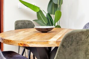 A round wooden table with a bowl on it, surrounded by chairs. - Chachacha Apartment At Sea with spectacular views and dining with an ocean view (Kralendijk)