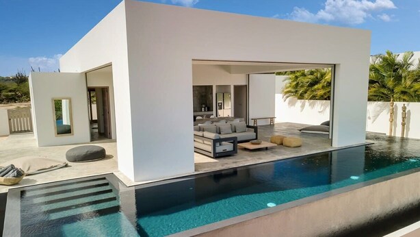 Uma casa moderna com piscina, área de estar externa e design minimalista.