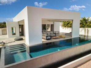 A modern house with a swimming pool, outdoor seating, and a minimalist design. - Villa Oaxaca Modern Villa with Lovely Private Pool (Kralendijk)