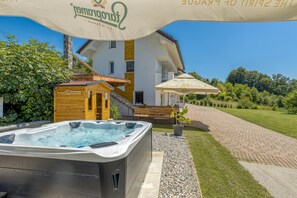 A spa area with a hot tub, wooden cabin, and outdoor seating. - Pool & Whirlpool Art Villas (Trebnje)