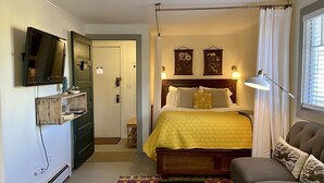 A bedroom with a bed, a TV, a sofa, and a desk. - Cozy Central Studio - Gunnison (Gunnison)