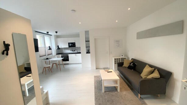 A modern apartment with a living room, kitchen, dining area, and a small balcony. - Apartment Schloofschdubb in Fuldatal Nähe Kassel (Fuldatal)