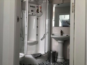 Een douche, een haardroger, een bidet, handdoeken