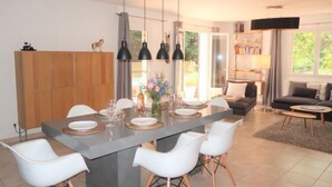 Una cucina moderna con un'isola centrale, sedie bianche e illuminazione a sospensione.