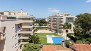 A residential building with multiple balconies, a swimming pool, and a view of the sea. - Bosc de la Montserrada by Interhome (La Pineda)