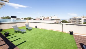 A rooftop terrace with artificial grass, two lounge chairs, and potted plants. - Bosc de la Montserrada by Interhome (La Pineda)