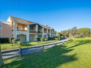 A multi-story hotel with a central courtyard, balconies, and a well-maintained lawn. - Hameau (N1 208) by Interhome (Agay Village Cap Esterel)