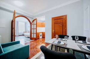 Hotellihuone, jossa on ruokailutila, kylpyhuone ja näkymä keittiöön.