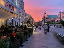 A street with outdoor seating at a restaurant named 'NEM ASIAN FUSION'.