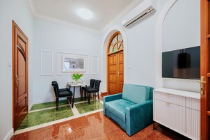 Ένα δωμάτιο με τραπέζι φαγητού, καρέκλες, έναν καναπέ, μια τηλεόραση και μια ντουλάπα.